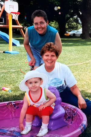 Cheryl Graham, Sylvia Graham, and a young Mary Jancovich pose for a photo in a backyard