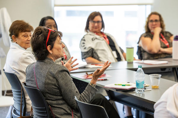 A Policy Academy participant speaks during an afternoon breakout session while other participants listen.