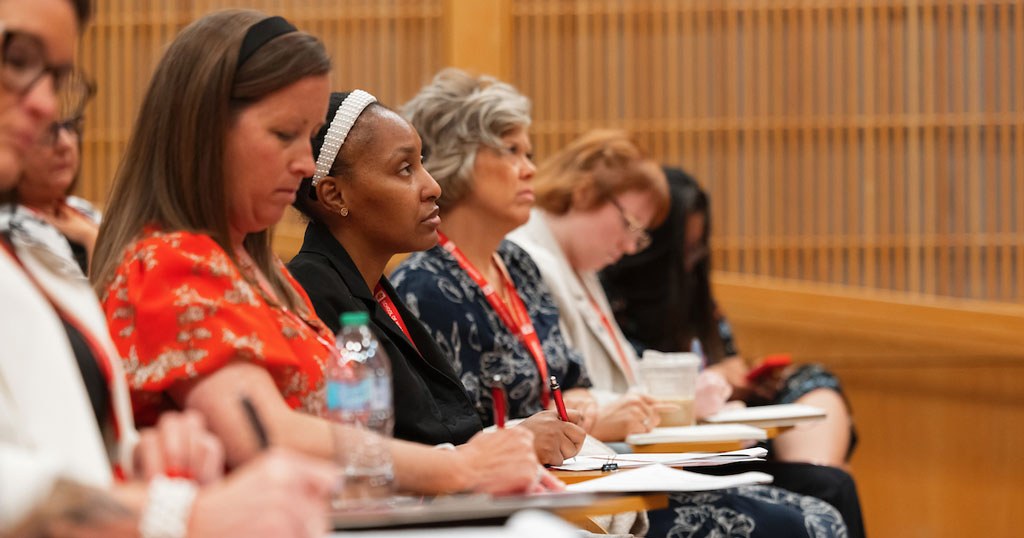 Several Policy Academy participants take notes during a panel discussion