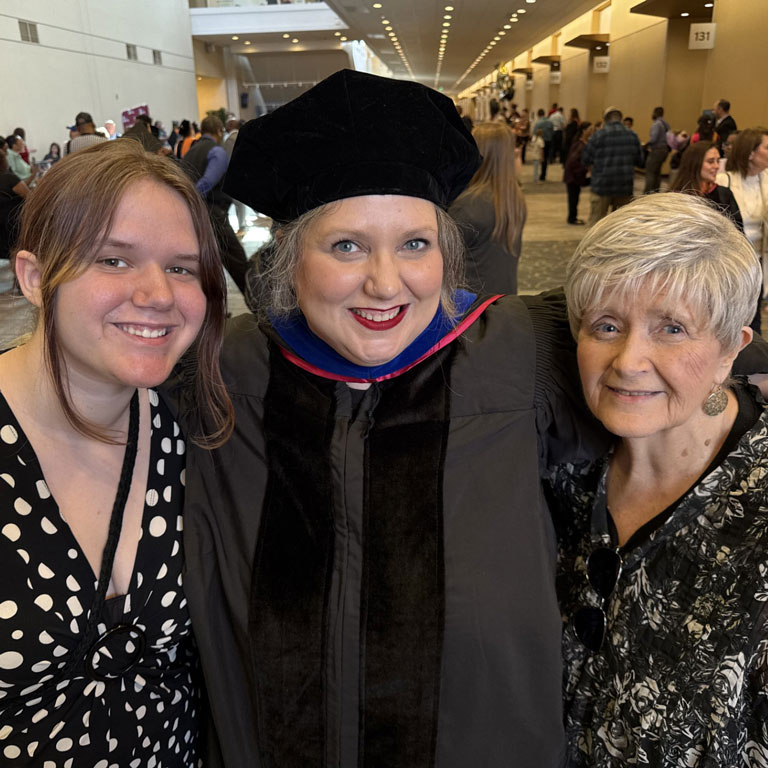 Dr. Erin Wyatt, center, poses for a photo between two family members during the 2026 Graduate Recognition Program at the Indiana Convention Center.
