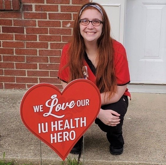 IUSON graduate with sign