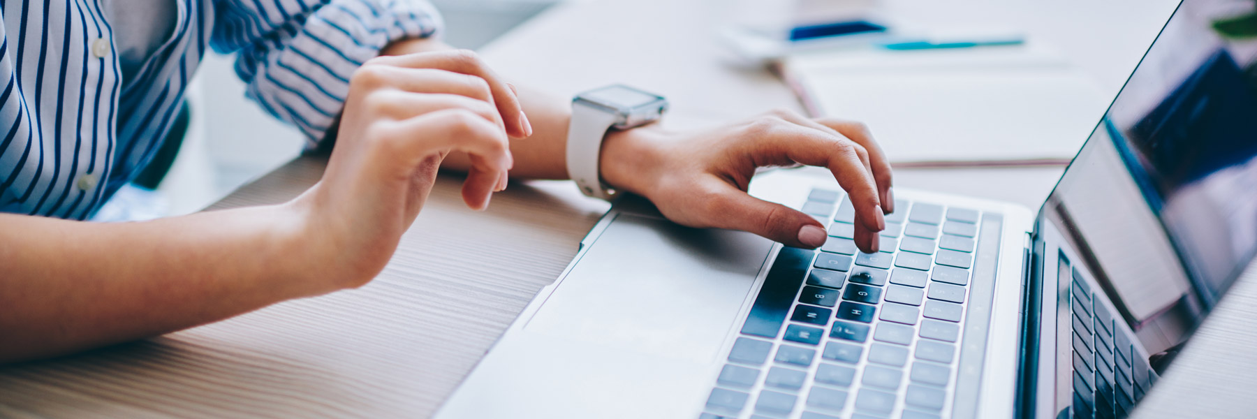 Close-up of hands typing on a laptop during an online application or form submission.